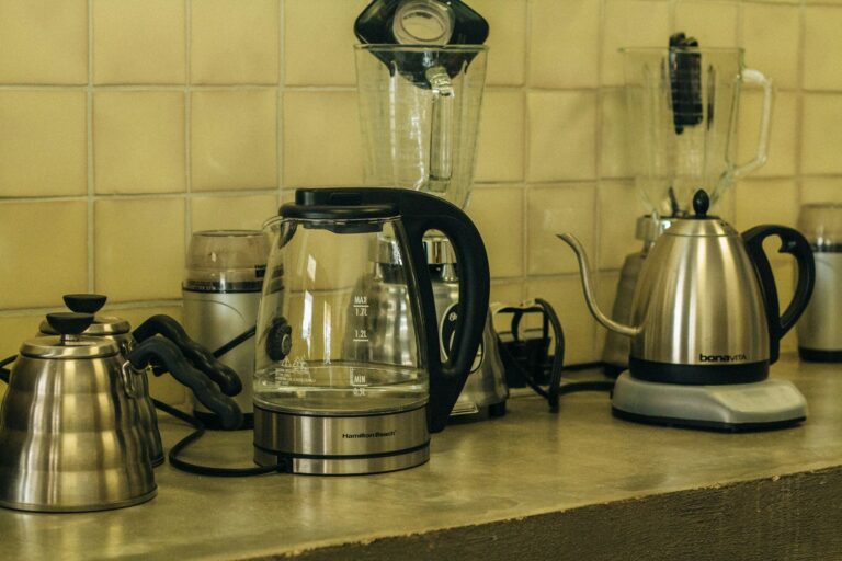 Mehrere Wasserkocher und Kessel aus Edelstahl auf einer Küchenarbeitsplatte