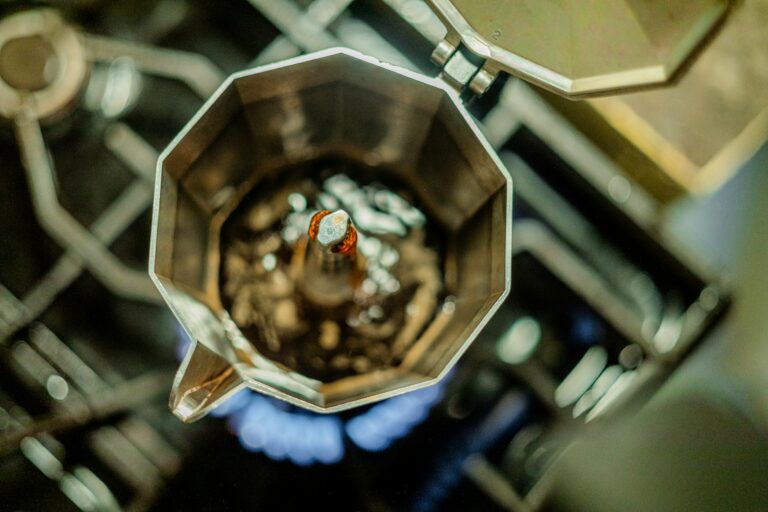 Espressokocher brüht Kaffee auf einer blauen Gasflamme