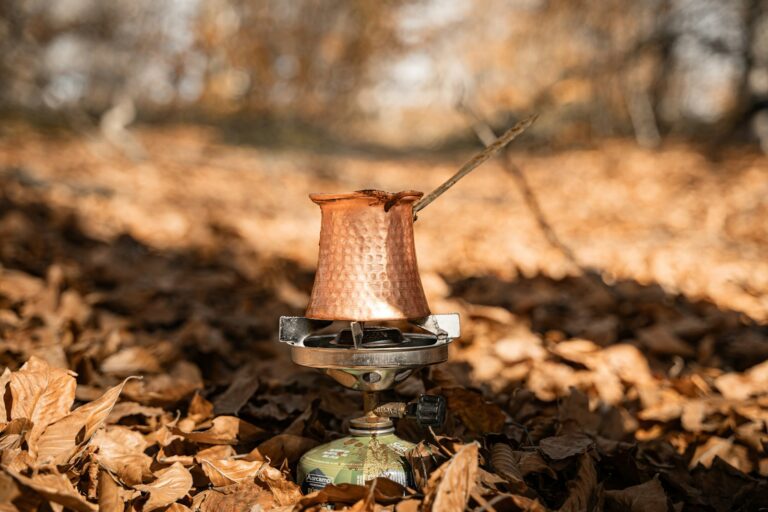 Kupferne Cezve mit Kaffee auf einem tragbaren Kocher im Freien