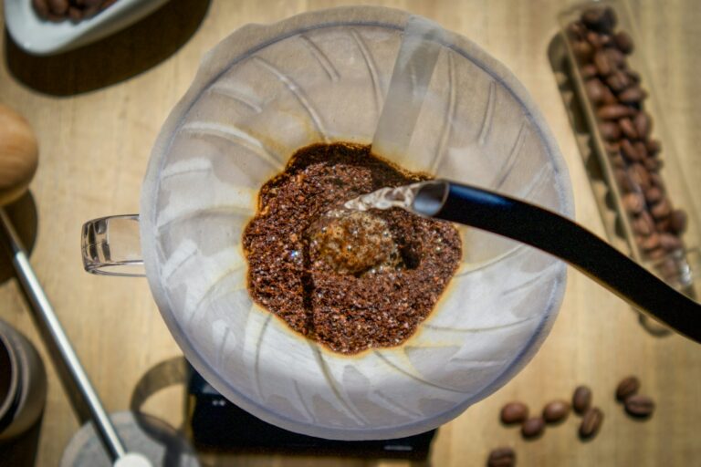 Heißes Wasser wird im Handfilter über gemahlenen Kaffee gegossen